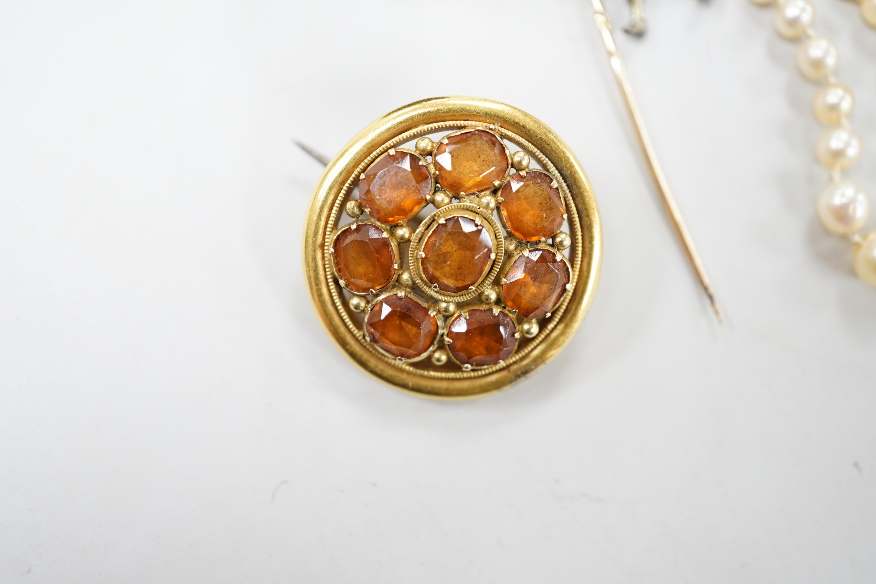 A 1920's? single strand graduated cultured pearl necklace, with 750 yellow metal, diamond and seed pearl set clasp, 44cm and three other items of jewellery including an early 20th century yellow metal and hessonite garne
